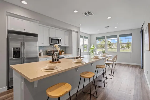 a kitchen with a dining table chairs and refrigerator