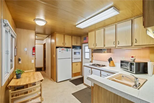 a kitchen with stainless steel appliances granite countertop a refrigerator and a stove top oven