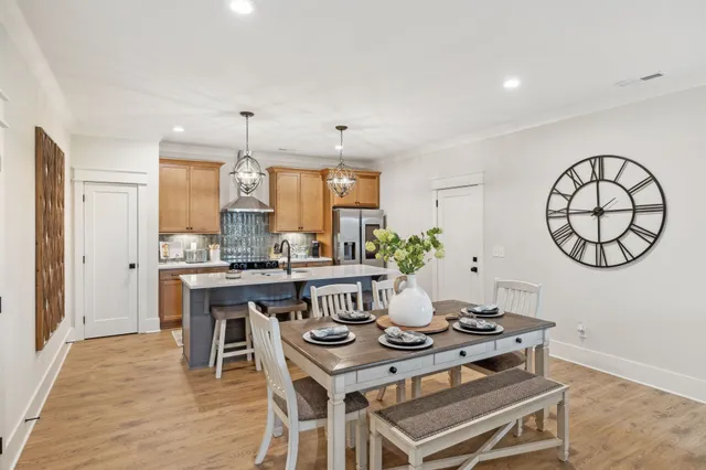 a kitchen with stainless steel appliances a table chairs in it and white cabinets
