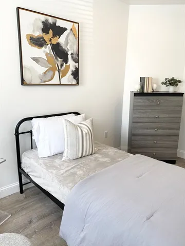 a bedroom with a bed and painting on the wall