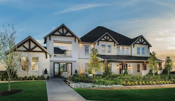 a front view of a house with a yard and potted plants