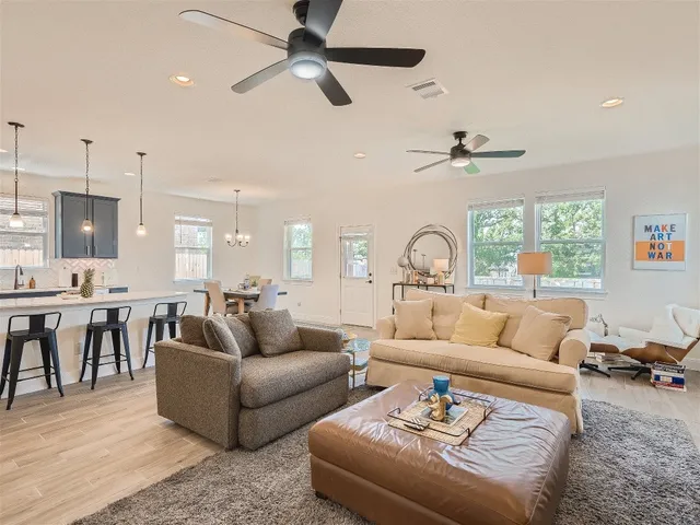 a living room with furniture and a flat screen tv with wooden floor