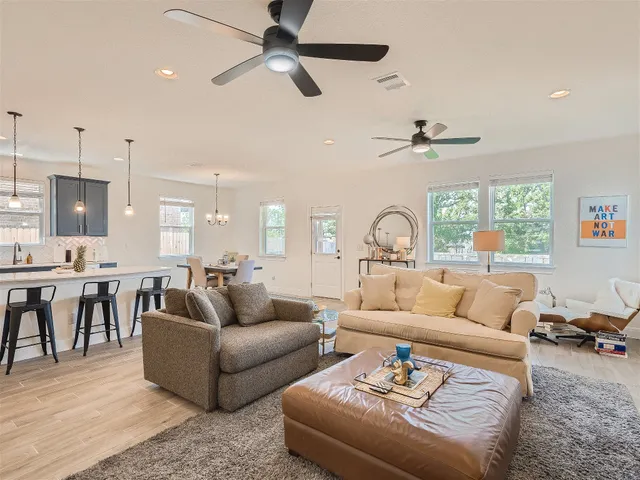 a living room with furniture and a flat screen tv with wooden floor
