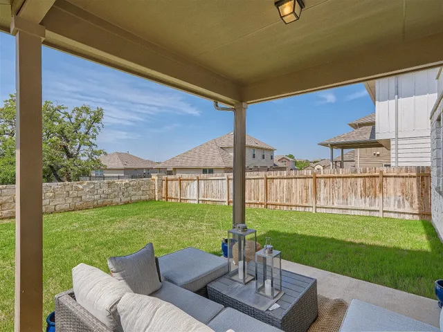 a view of a patio with a table chairs and a yard