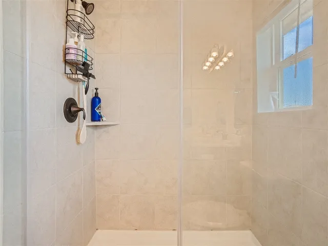 a bedroom with a bed a window and a flat screen tv