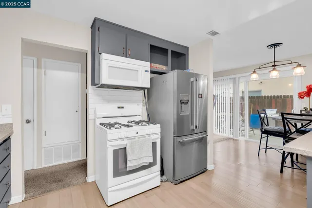 a kitchen with stainless steel appliances a refrigerator and a stove top oven