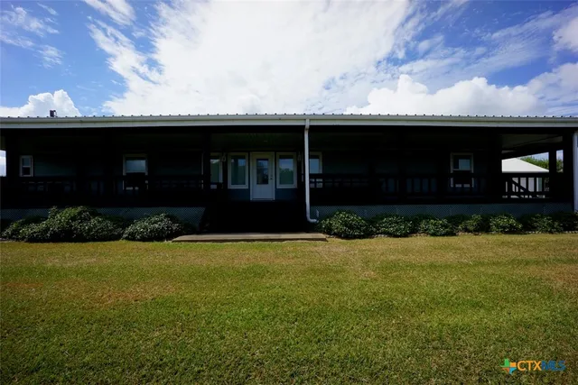 a view of a trees with yard in front of house