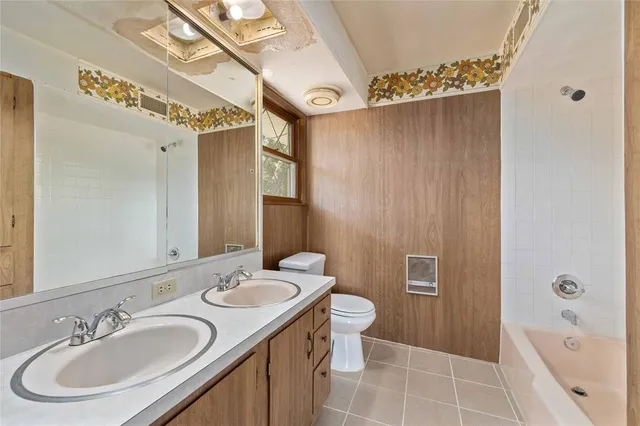 a bathroom with a sink a toilet a mirror and shower