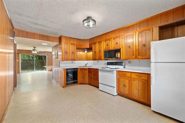 a large kitchen with stainless steel appliances granite countertop a refrigerator a stove and a sink with cabinets