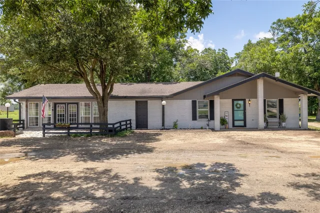 a front view of a house with a yard and trees