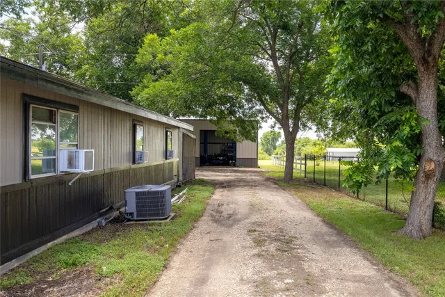 a front view of a house with a garden and trees