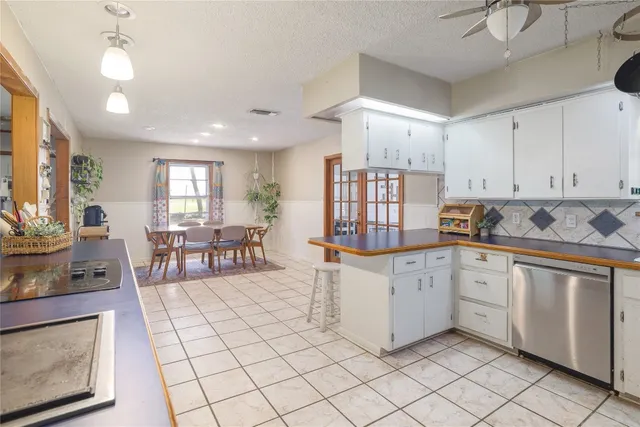 a kitchen with white cabinets and chairs