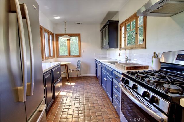 a kitchen with stainless steel appliances granite countertop a stove a sink and a refrigerator