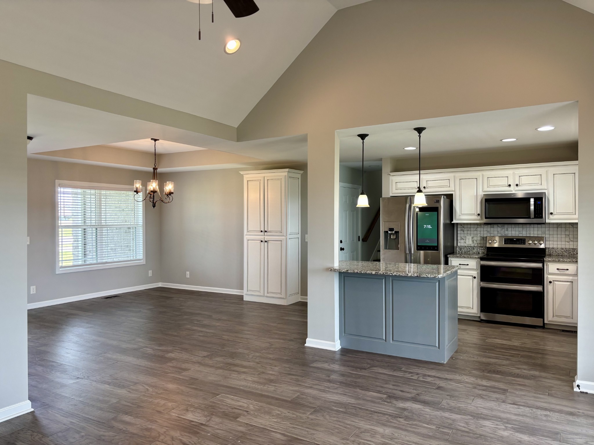 51 Regency Place Manchester, TN 37355 - Photo 3 of 27 an empty room with wooden floor a kitchen view and windows