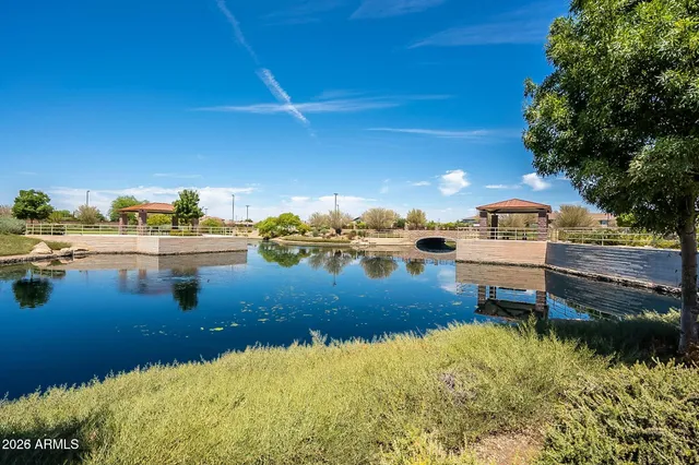 a view of a swimming pool with chairs in front of a house