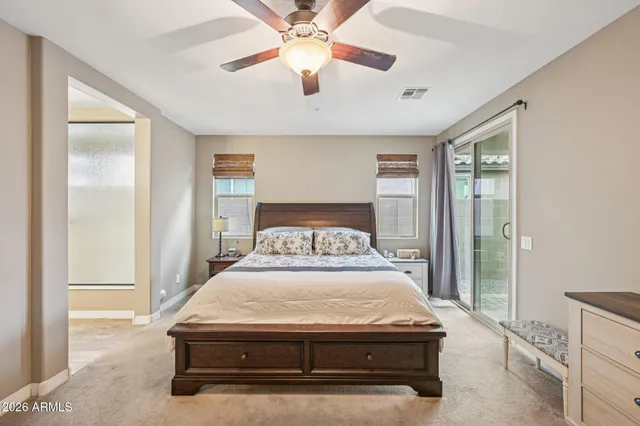 a room with a bed and a chandelier fan