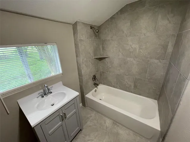 a bathroom with a bath tub a sink and a window