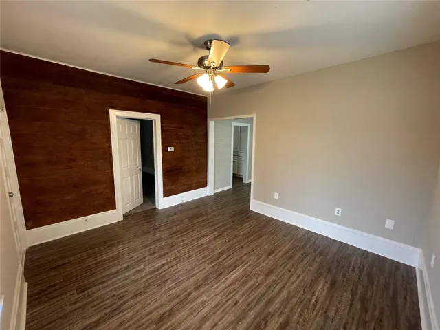 a view of a livingroom with a ceiling fan and wooden floor