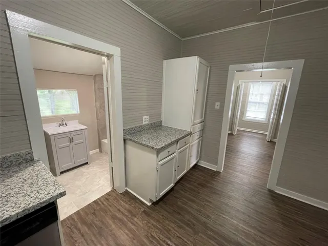 a kitchen with granite countertop a sink and a stove top oven
