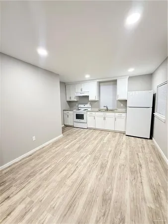 a kitchen with wooden floors and white appliances