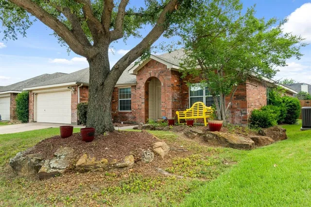 a backyard of a house with table and chairs plants and large trees