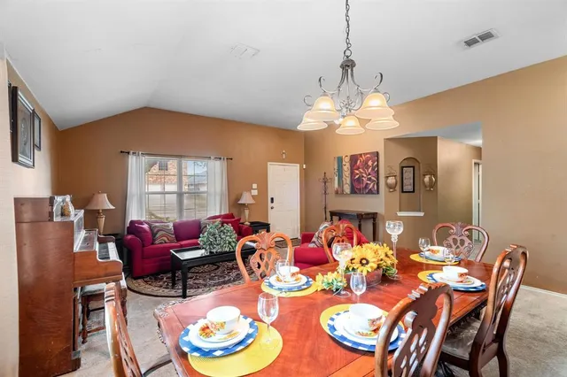 a dining room with furniture and a chandelier