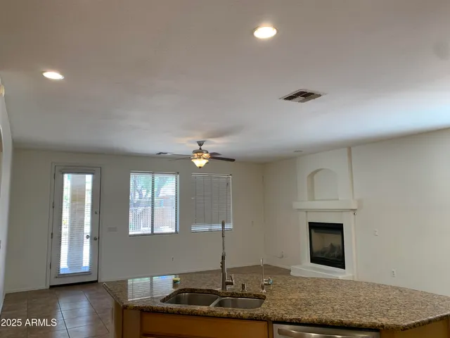 a kitchen with granite countertop a sink a counter top space and cabinets