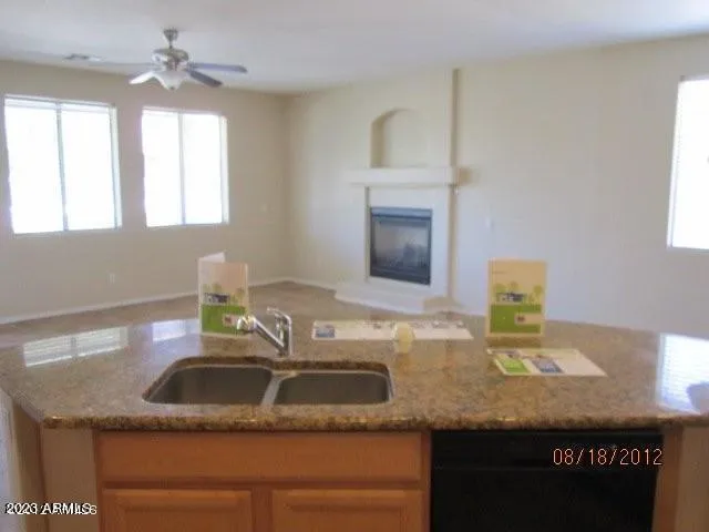 a kitchen with stainless steel appliances granite countertop a stove top oven a sink and a refrigerator