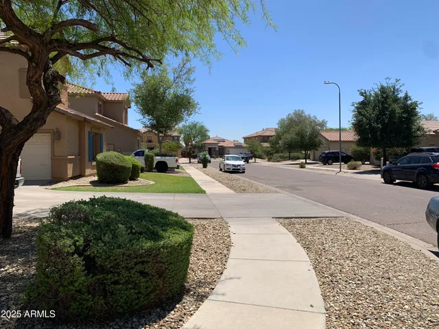 a front view of a house with a garden and tree