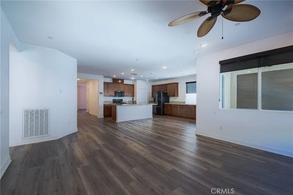 a view of a kitchen with wooden floor and a ceiling fan