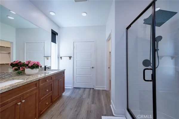 a spacious bathroom with a granite countertop sink a mirror and shower