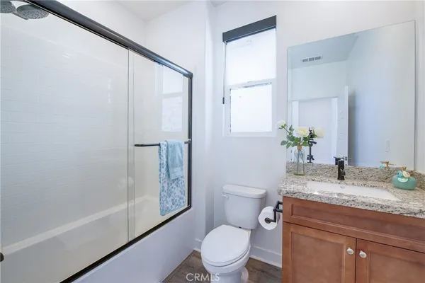 a bathroom with a granite countertop sink toilet and shower