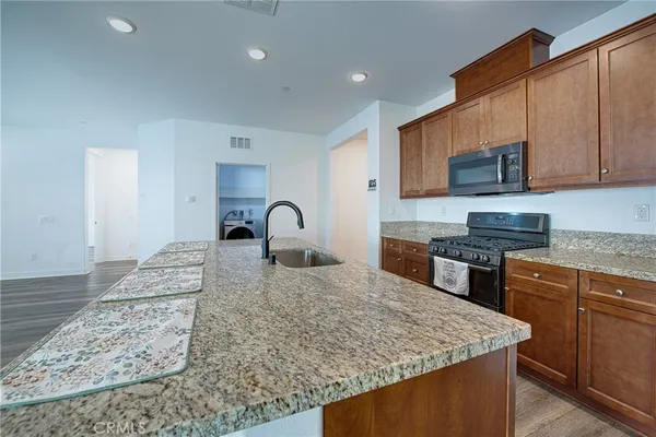 a kitchen with stainless steel appliances granite countertop a sink stove and refrigerator