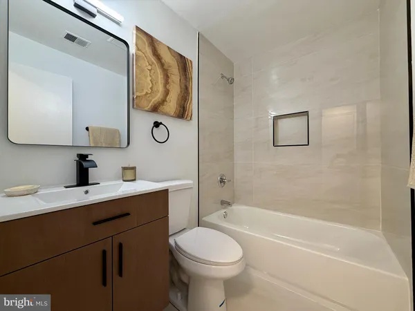 a bathroom with a toilet sink vanity tub and shower