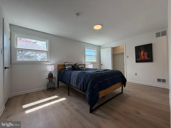 a spacious bedroom with a bed and wooden floor