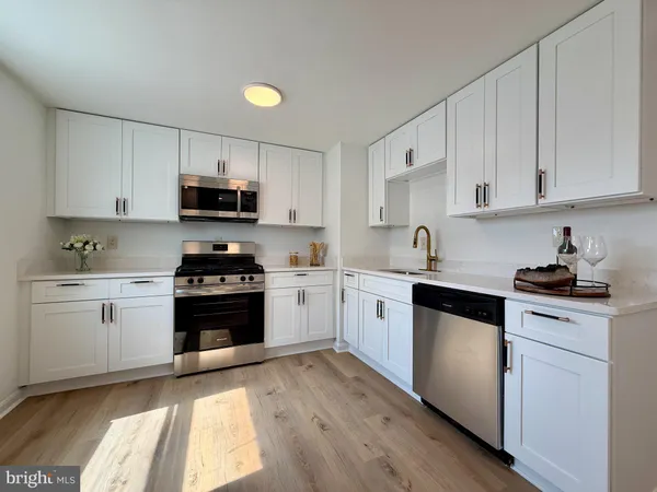 a kitchen with granite countertop white cabinets and stainless steel appliances