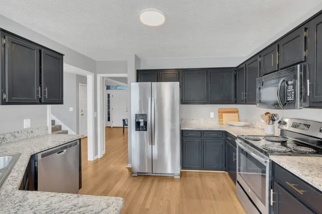 a kitchen with a refrigerator sink and wooden cabinets