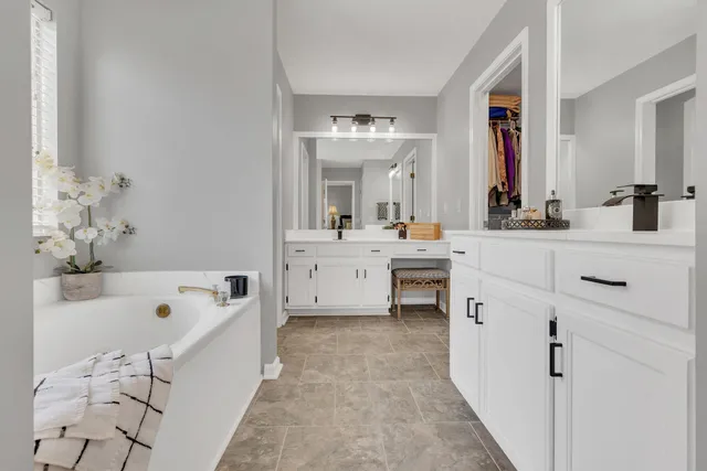 a bathroom with a tub sink and mirror