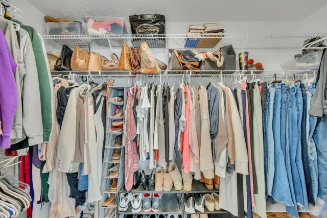 a view of walk in closet with clothes