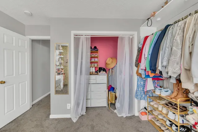 a view of walk in closet with clothes and shoes