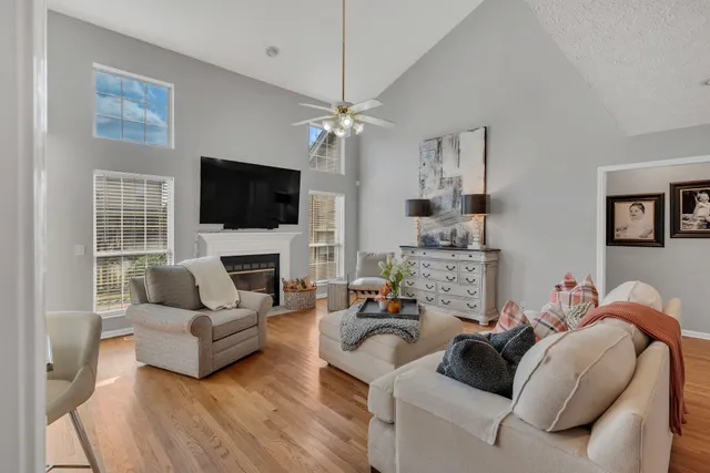 a living room with furniture a flat screen tv and a fireplace