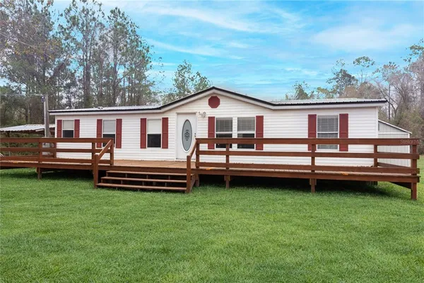 a view of a house with a yard and sitting area