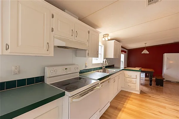 a kitchen with stainless steel appliances granite countertop a sink and cabinets with wooden floor