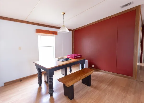 a view of a room with wooden floor and a ceiling fan