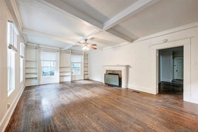 wooden floor fireplace and windows in an empty room