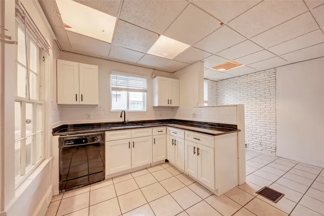 a kitchen with granite countertop white cabinets and appliances