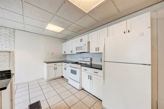 a kitchen with white cabinets and white appliances