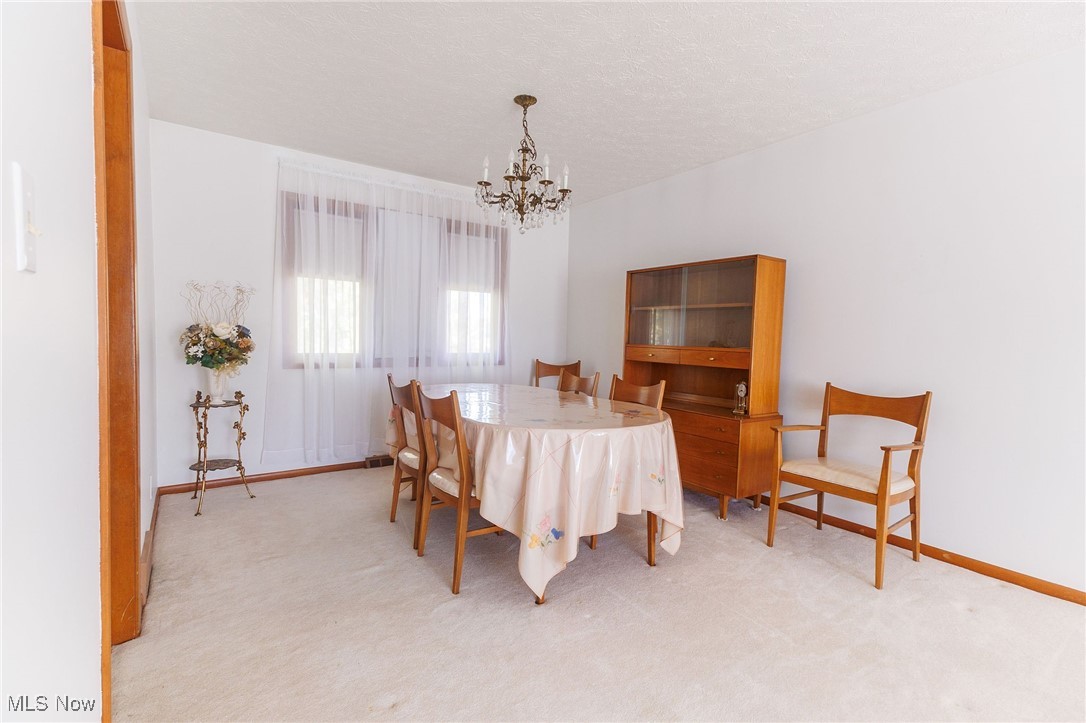 966 Brainard Road Cleveland, OH 44143 - Photo 16 of 50 Carpeted dining room featuring a textured ceiling and a chandelier