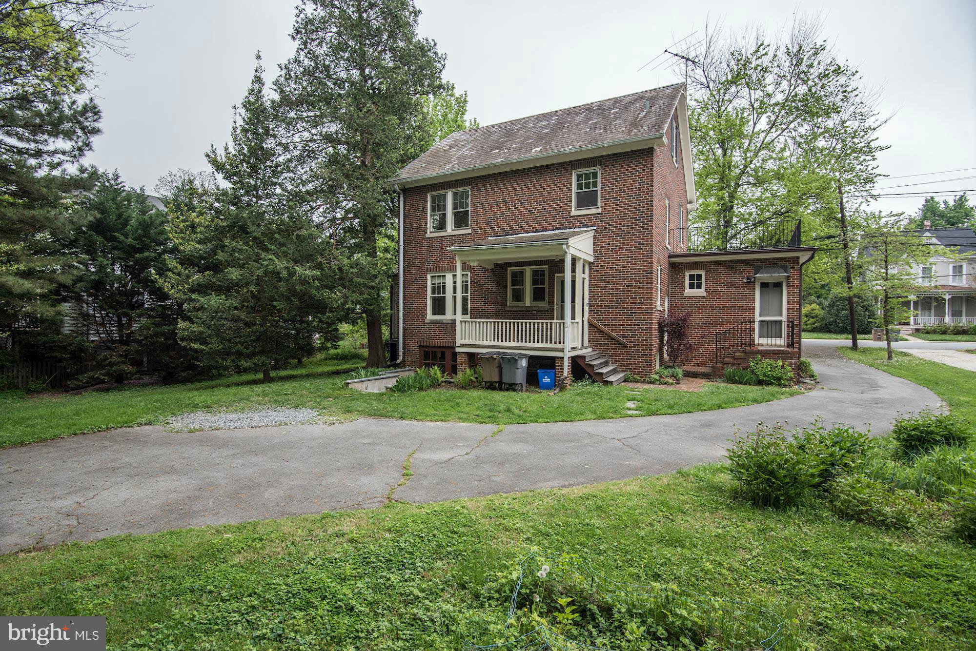 210 Baltimore Road Rockville, MD 20850 - Photo 25 of 30 a brick house with small yard and a large tree