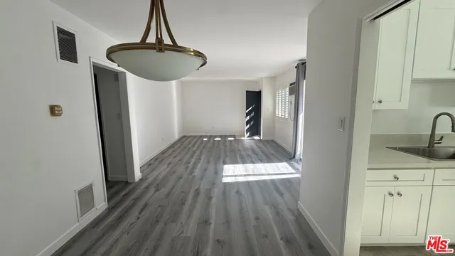a view of a kitchen with wooden floor cabinets and a sink